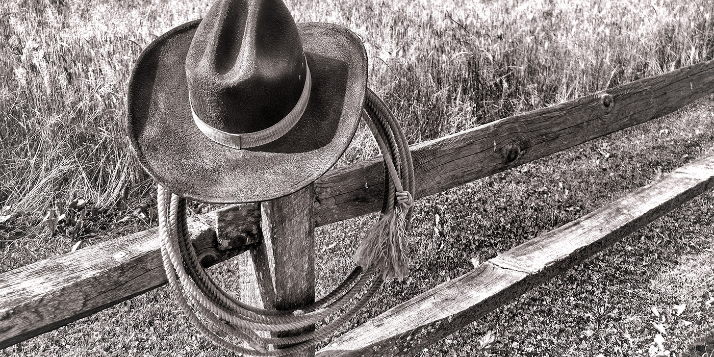 west-rodeo-cowboy-hat-and-lariat-on-fence